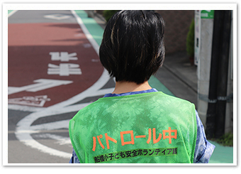 写真：緑のベストは、子供たちにとって「安心の目印」（尾﨑さんは普段からベストを着用して買い物等に行くそうです。）